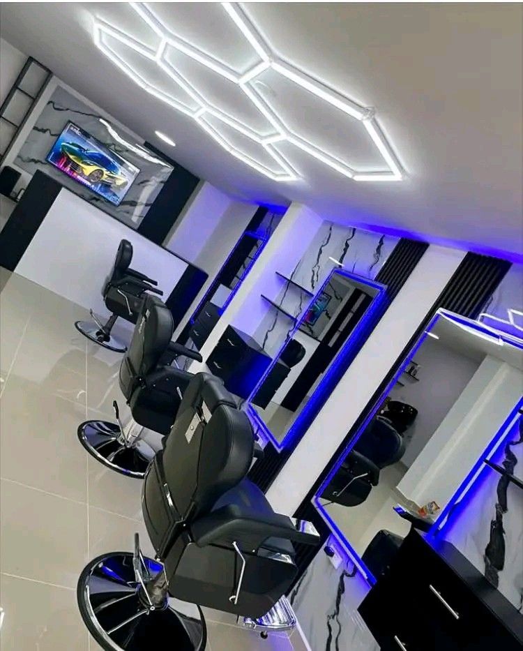 Elegant barbershop with blue and teal tones, modern LED lighting, leather chairs and sophisticated atmosphere
