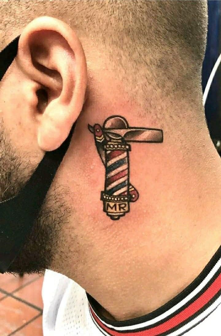 Tatuaje cultural de barbero con composición artística que combina símbolos tradicionales de barbería, representando la historia y cultura del oficio